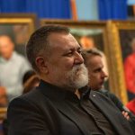 писатель Василий Дворцов на фоне портретов Алмазова